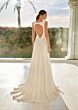 Abito da sposa Cora con schiena scoperta, silhouette elegante, sfondo naturale.