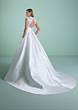 Abito da sposa CORINTIA con schiena scoperta e gonna ampia, sfondo verde.