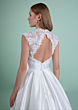 Abito da sposa CORINTIA con schiena scoperta e dettagli in pizzo floreale, sfondo verde.