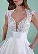 Abito da sposa CORINTIA con corpetto in pizzo floreale e gonna ampia, sfondo verde pastello.