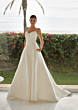 Abito da sposa LYLA St. Patrick, elegante con spalline sottili, sfondo tropicale.