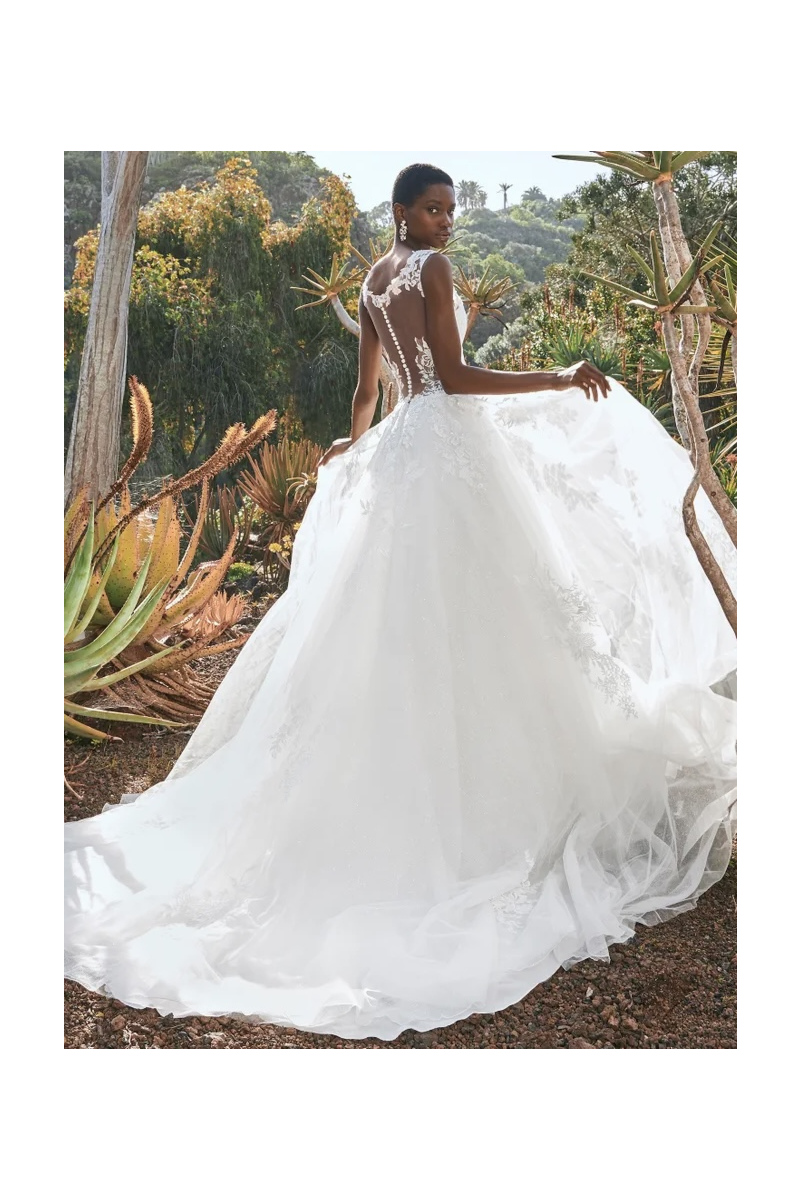 Abito da sposa Pronovias Borealis, schiena scoperta, pizzo floreale, ambientazione naturale con piante.