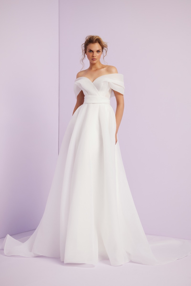 Abito da sposa bianco L217 Linea Ariamo, spalle scoperte, sfondo lilla.