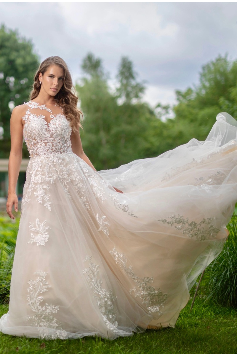 Abito da sposa Nike Atelier, pizzo floreale su sfondo naturale, eleganza moderna e raffinata.