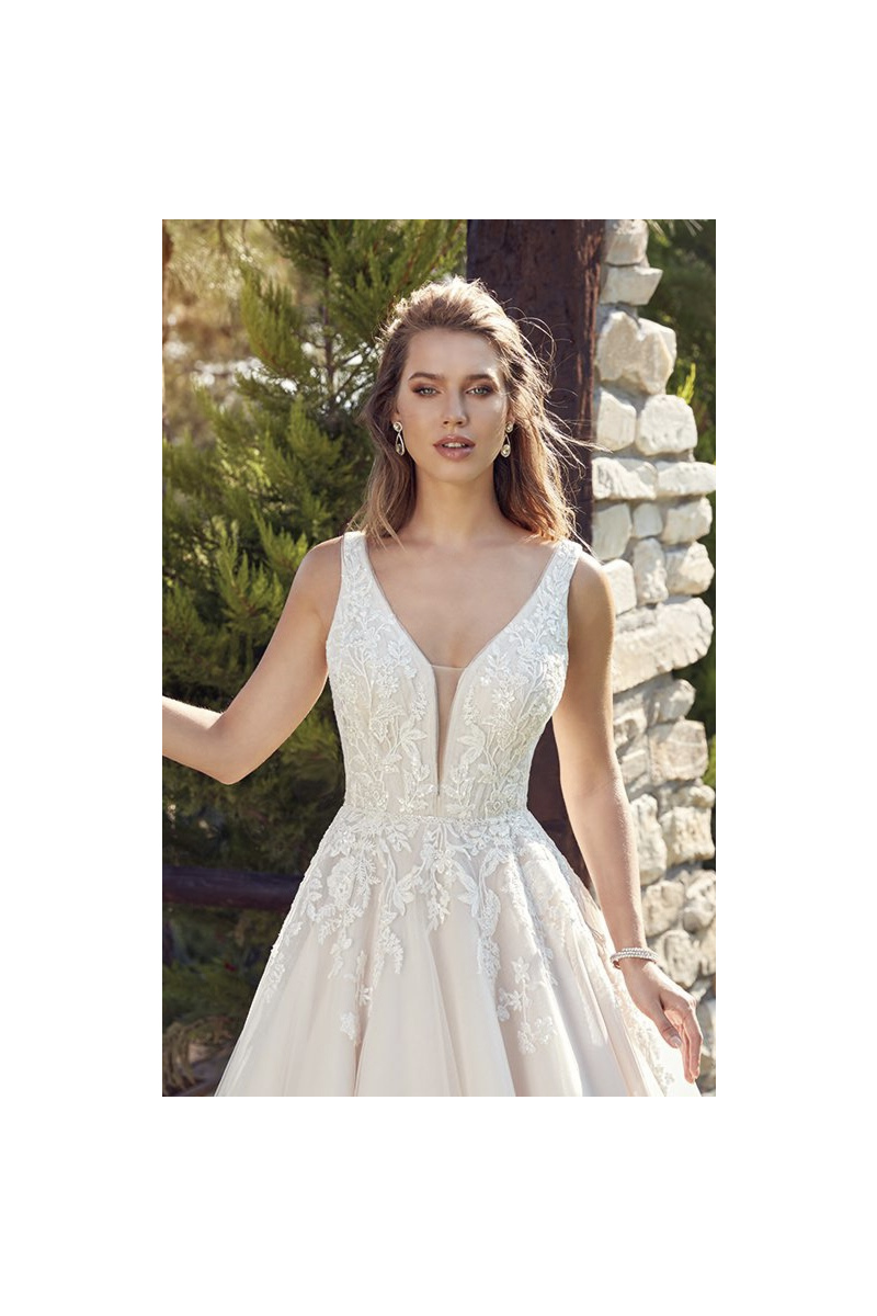 Abito da sposa Robyn Eddy K con dettagli in pizzo, scollo a V, ambientazione naturale.