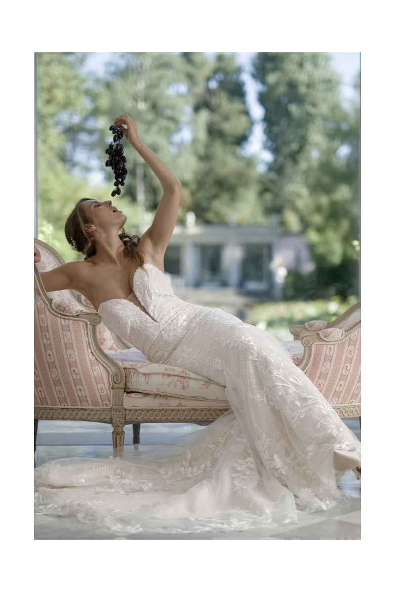 Abito da sposa Demetra Linea SposaE, donna elegante su divano vintage con grappolo d'uva, sfondo naturale.