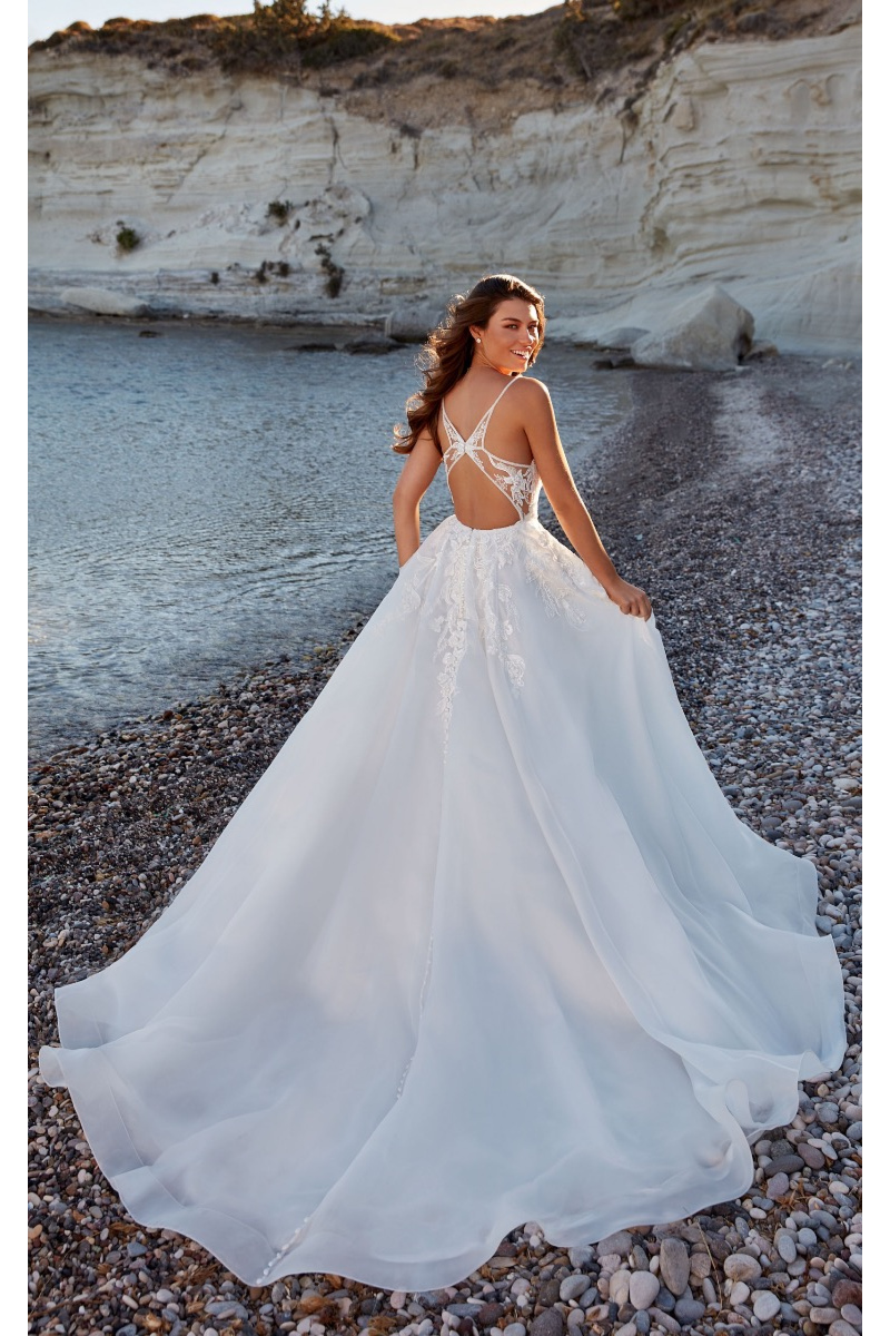Abito da sposa Viviana Eddy K, schiena scoperta, spiaggia rocciosa, atmosfera romantica.