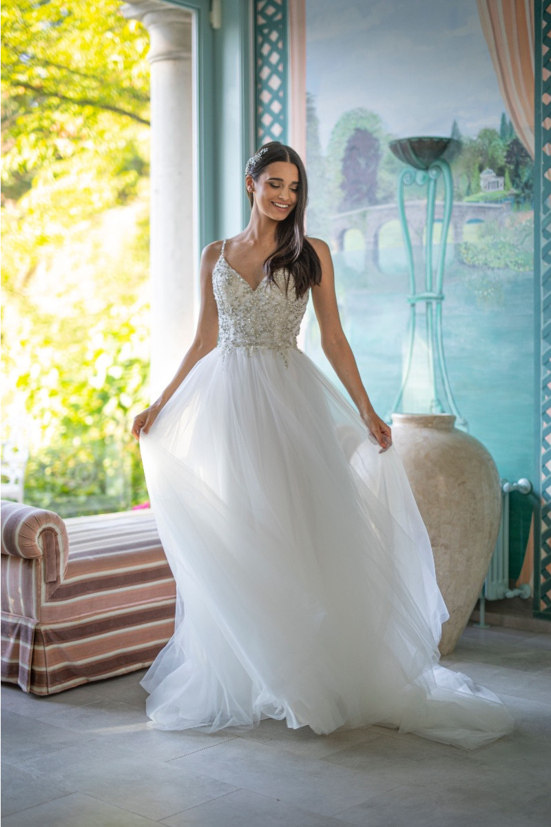 Abito da sposa Andromaca linea sposae atelier, con corpetto ricamato e gonna in tulle, in ambientazione elegante.