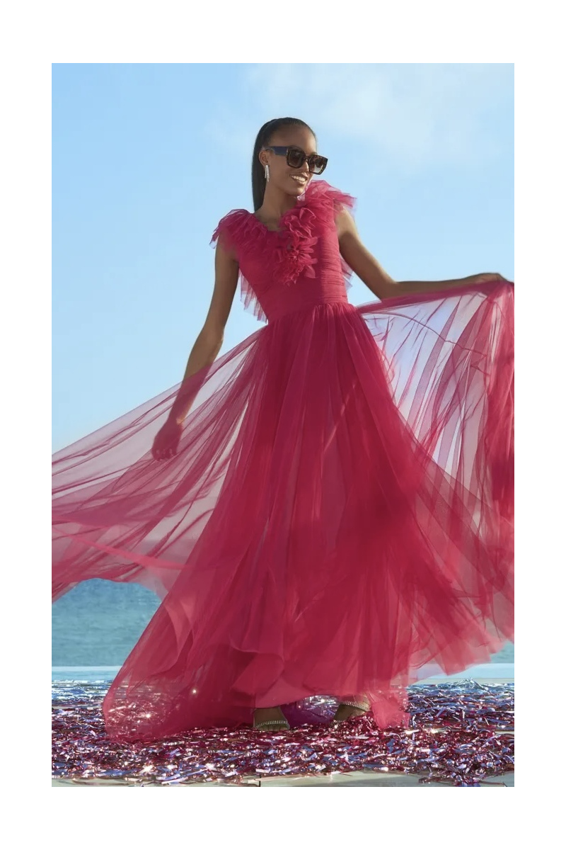 Abito lungo rosa Pronovias Ruffles 158, tessuto leggero e dettagli floreali, indossato da modella con occhiali da sole.