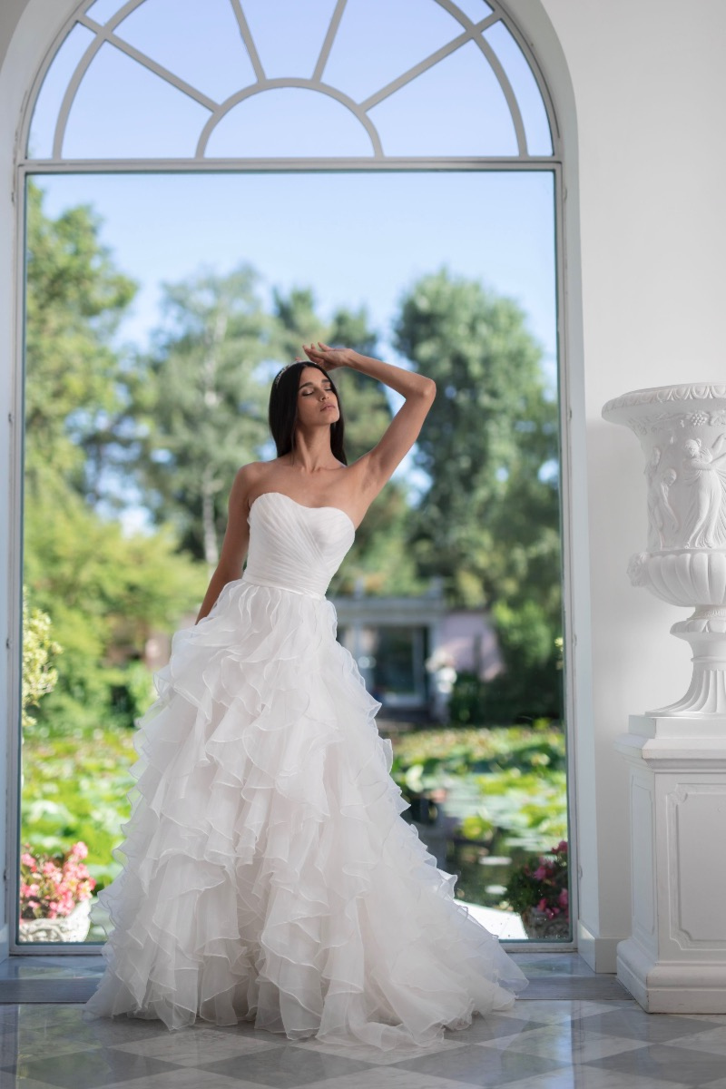 Abito da sposa Peonia di Linea Sposa Atelier, design senza spalline, ambientato in giardino elegante.