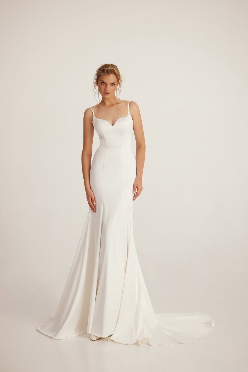 Abito da sposa bianco elegante L203 Linea Ariamo, spalline sottili, silhouette fluida, sfondo neutro.