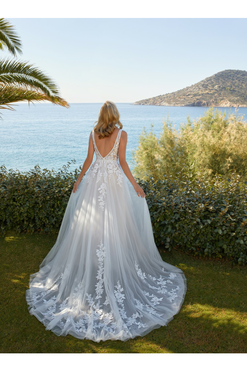 Abito da sposa Cosmobella 8126, vista posteriore, con dettagli floreali, sfondo mare e natura.