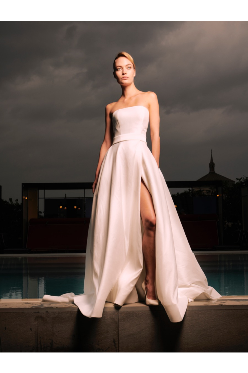Abito da sposa Shanghai Sposae Essential, elegante e moderno, con spacco, indossato all'aperto con cielo nuvoloso.
