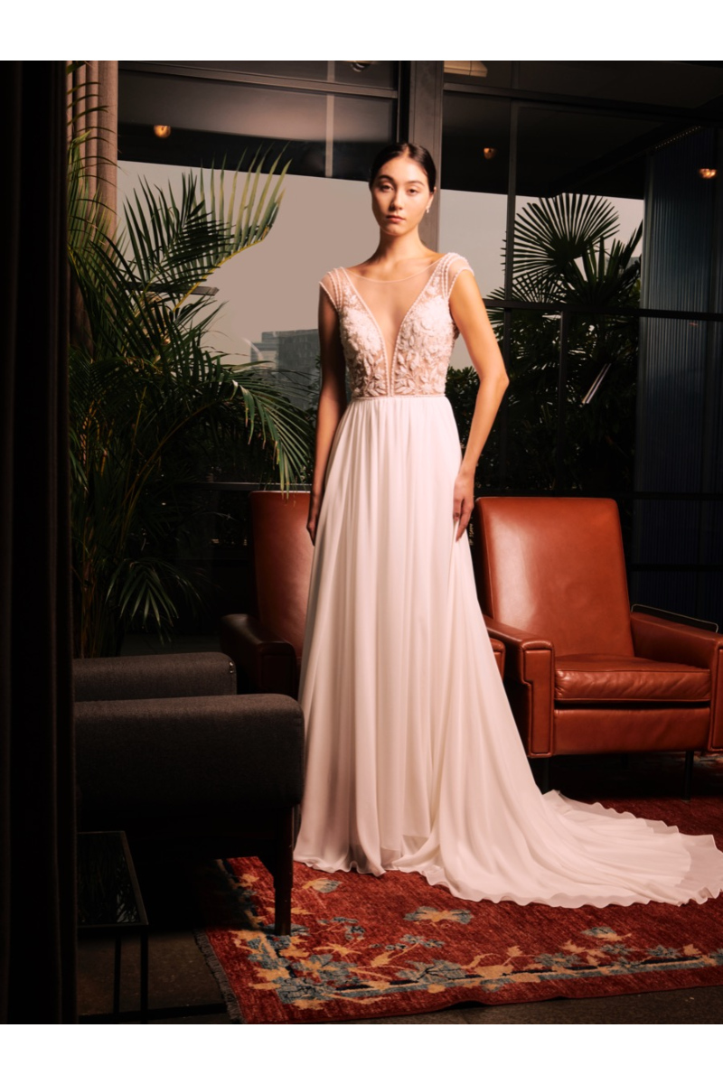 Abito da sposa Vienna Sposae Essential con dettagli floreali, ambientato in un elegante salotto moderno.