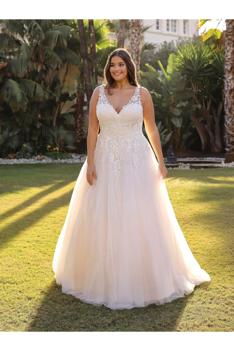 Abito da sposa ANNI Ladybird in pizzo bianco, modello elegante all'aperto su prato verde.