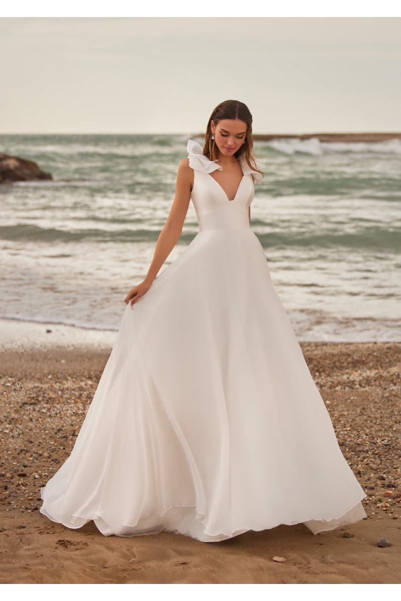 Abito da sposa ARIA di St. Patrick sulla spiaggia, scollo a V e dettagli floreali.