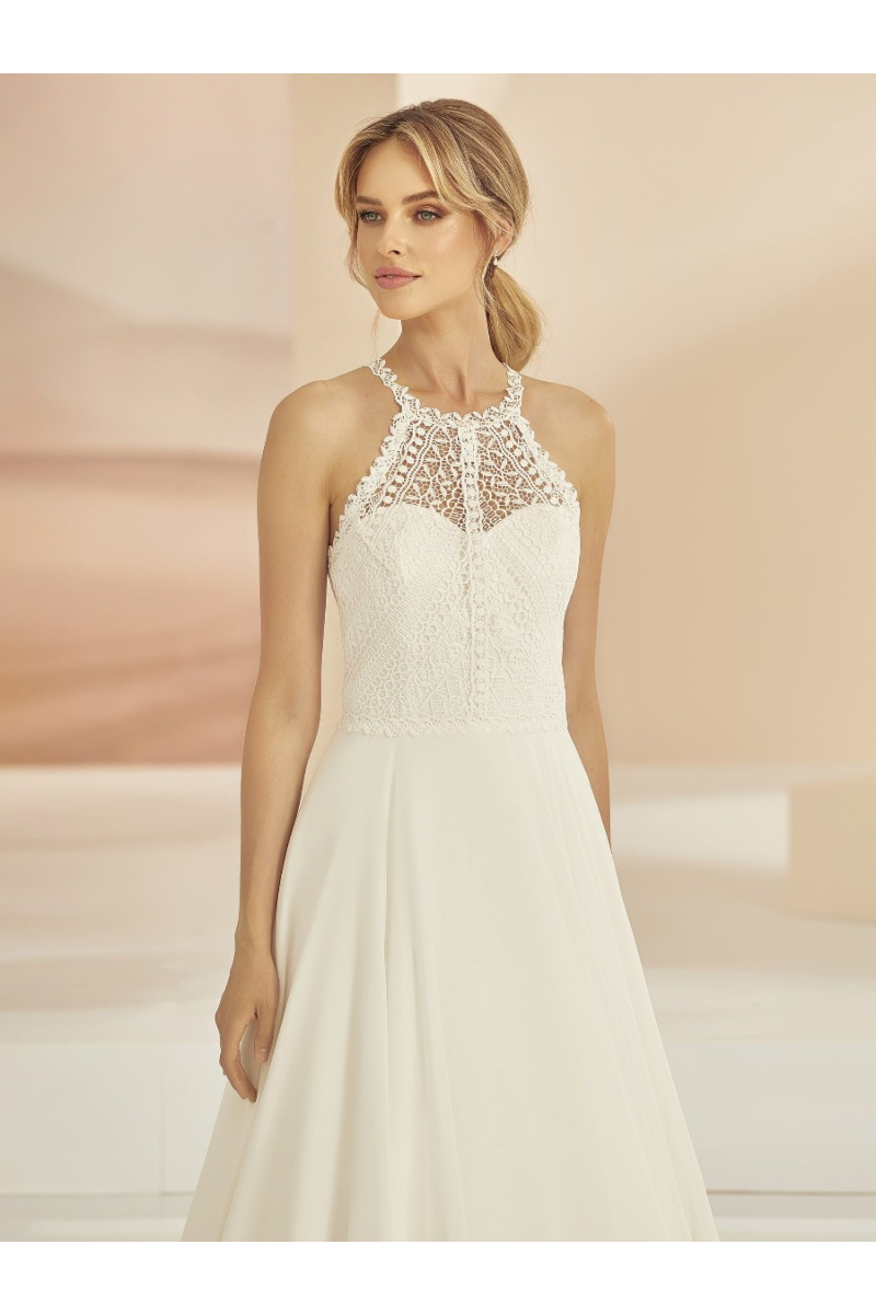 Abito da sposa Aurora in pizzo con scollo all'americana, stile elegante e moderno.