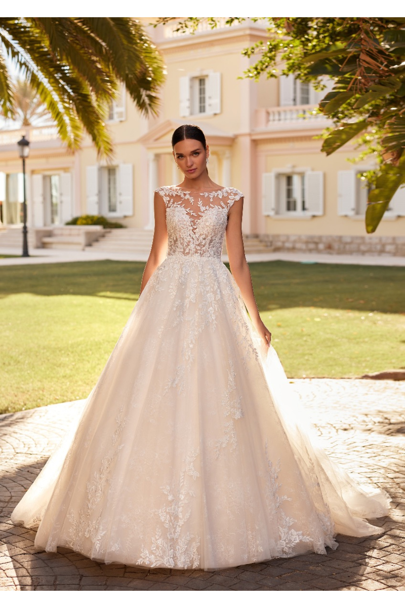 Abito da sposa CARRISA St. Patrick, elegante con dettagli in pizzo, sfondo villa e giardino.