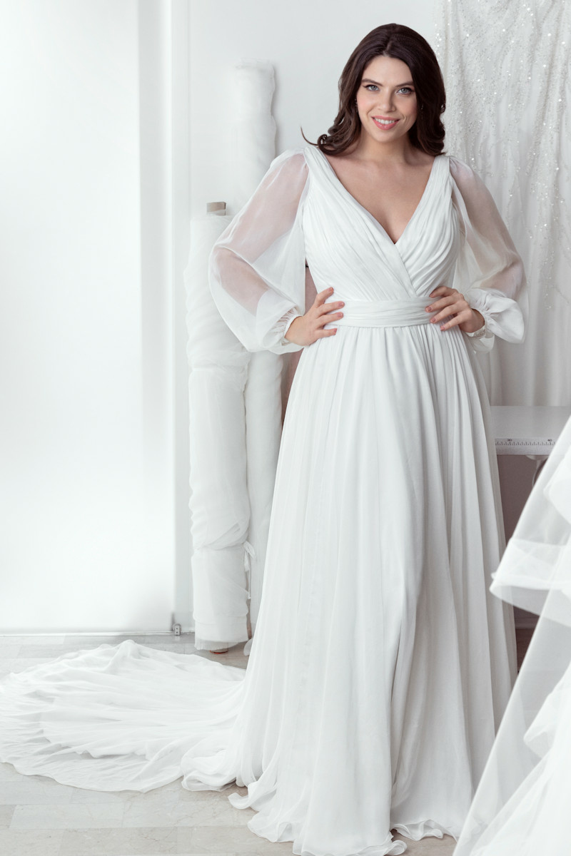 Abito da sposa curvy Jamie con maniche trasparenti e scollo a V, stile elegante e moderno.