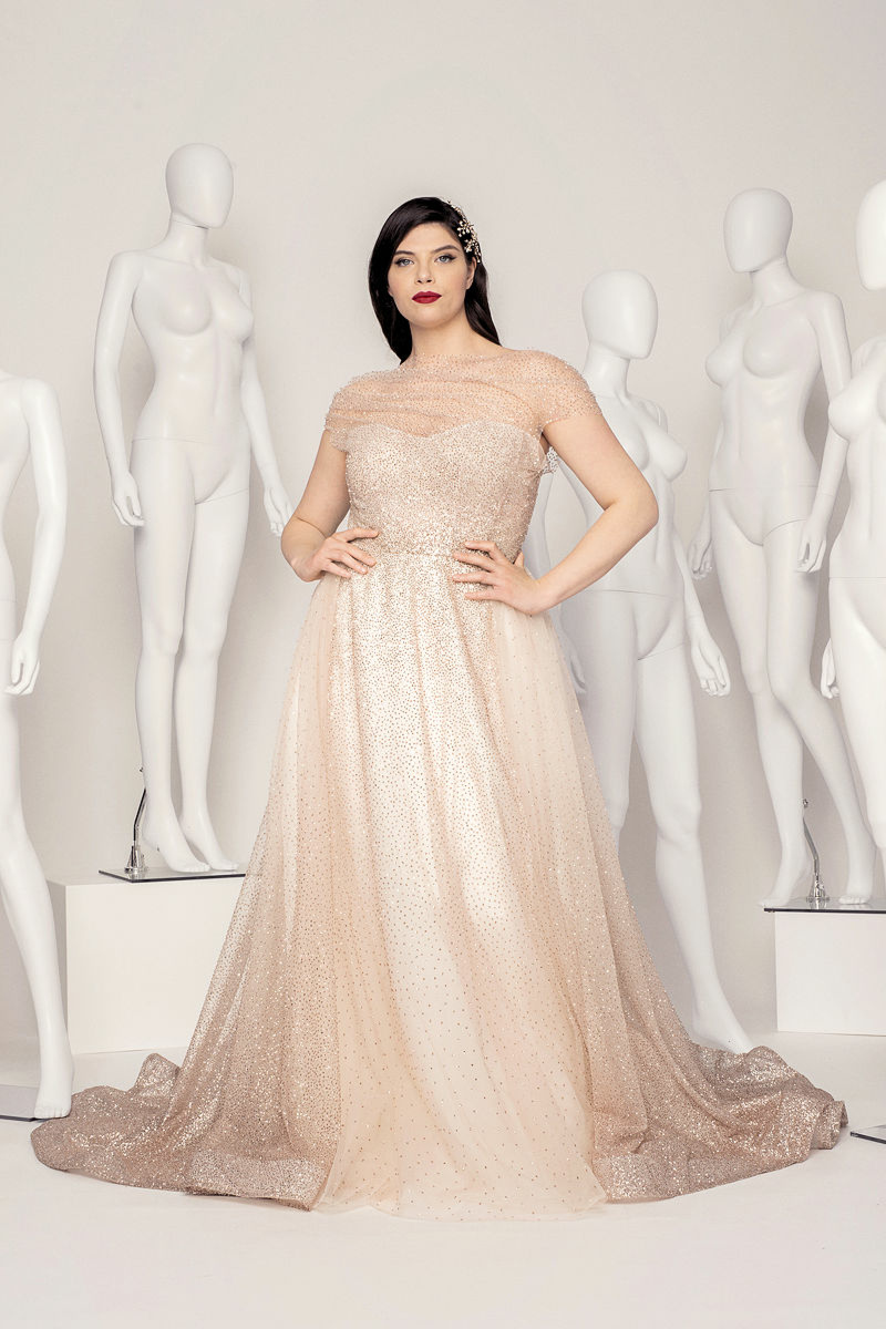 Abito da sposa curvy HEDY in tulle glitterato, modella tra manichini bianchi.