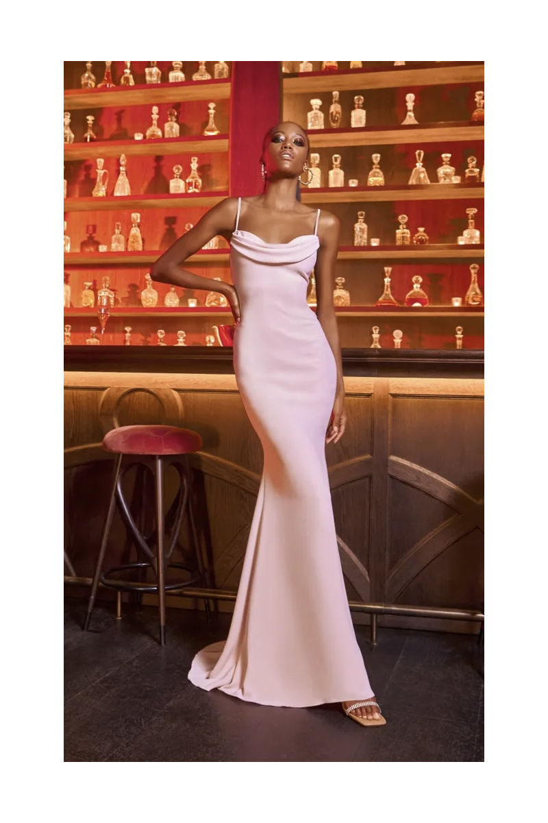 Abito da sera rosa Pronovias ESSENTIAL 2250, design elegante con spalline sottili, sfondo bar con bottiglie.