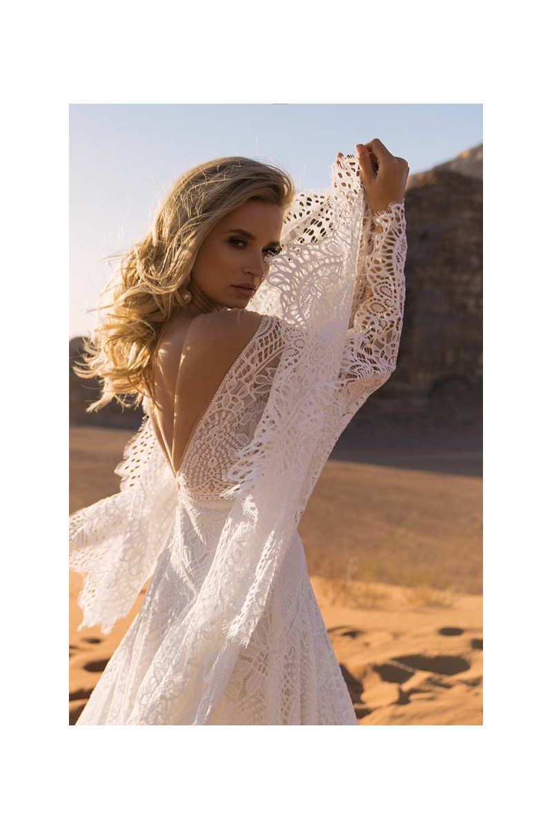 Abito da sposa LEA - DAMA in pizzo bianco, maniche lunghe, sfondo desertico.