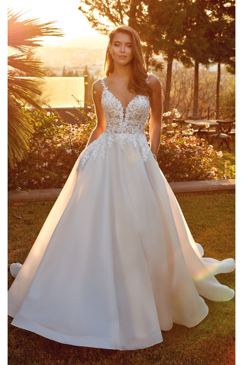 Abito da sposa Darcy di Eddy K in giardino al tramonto, con dettagli in pizzo e gonna ampia.