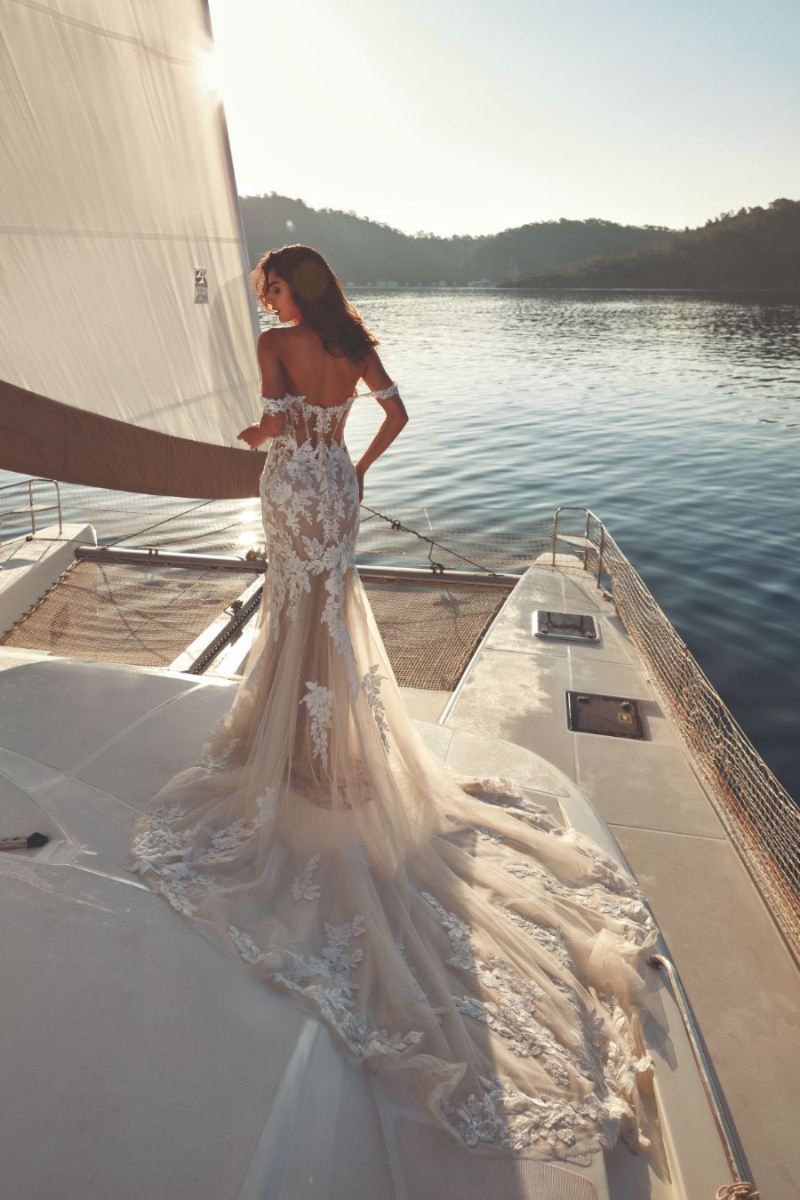 Abito da sposa Alanis di Eddy K su yacht al tramonto, design elegante e dettagli in pizzo.