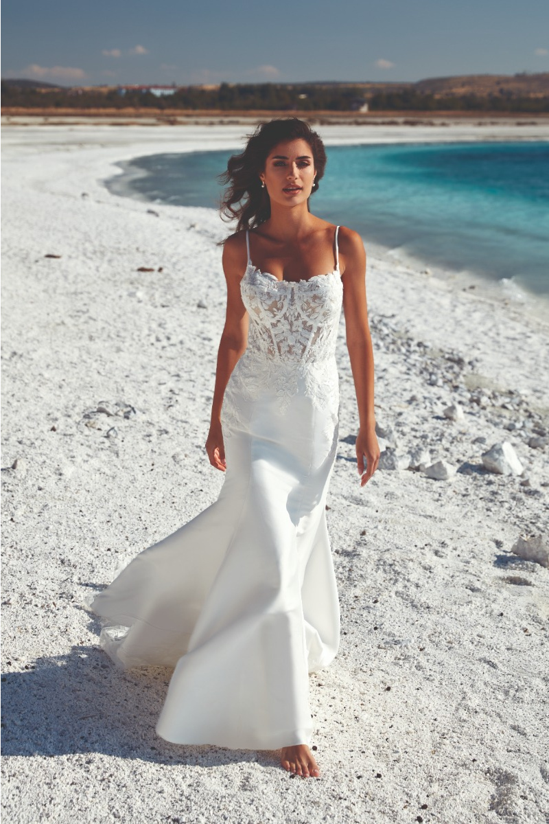 Abito da sposa Miami di Eddy K, donna su spiaggia bianca con mare turchese sullo sfondo.