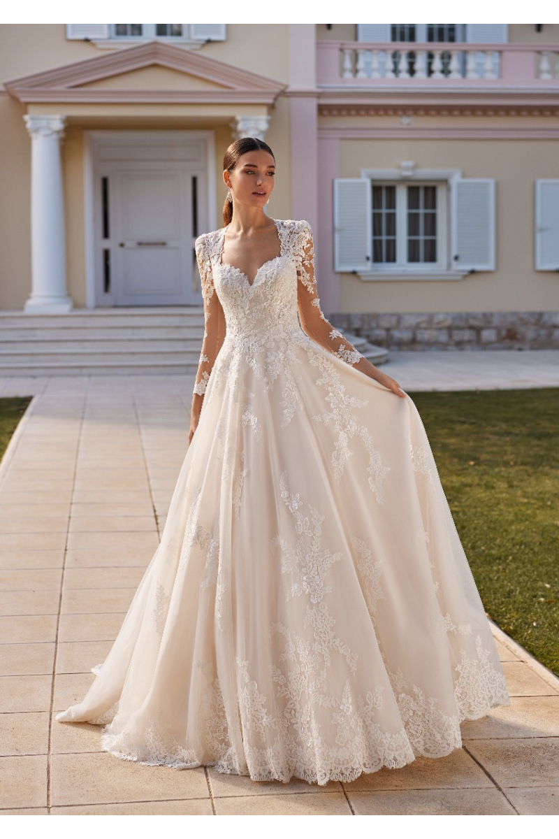 Abito da sposa Edwina St. Patrick in pizzo con maniche lunghe, sfondo villa elegante.