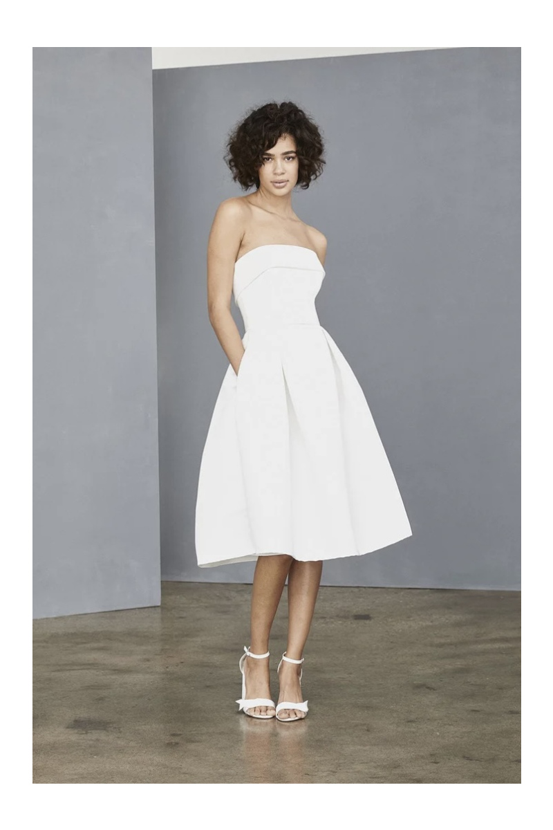 Abito bianco senza spalline Amsale Lw140, lunghezza al ginocchio, indossato da modella in studio.