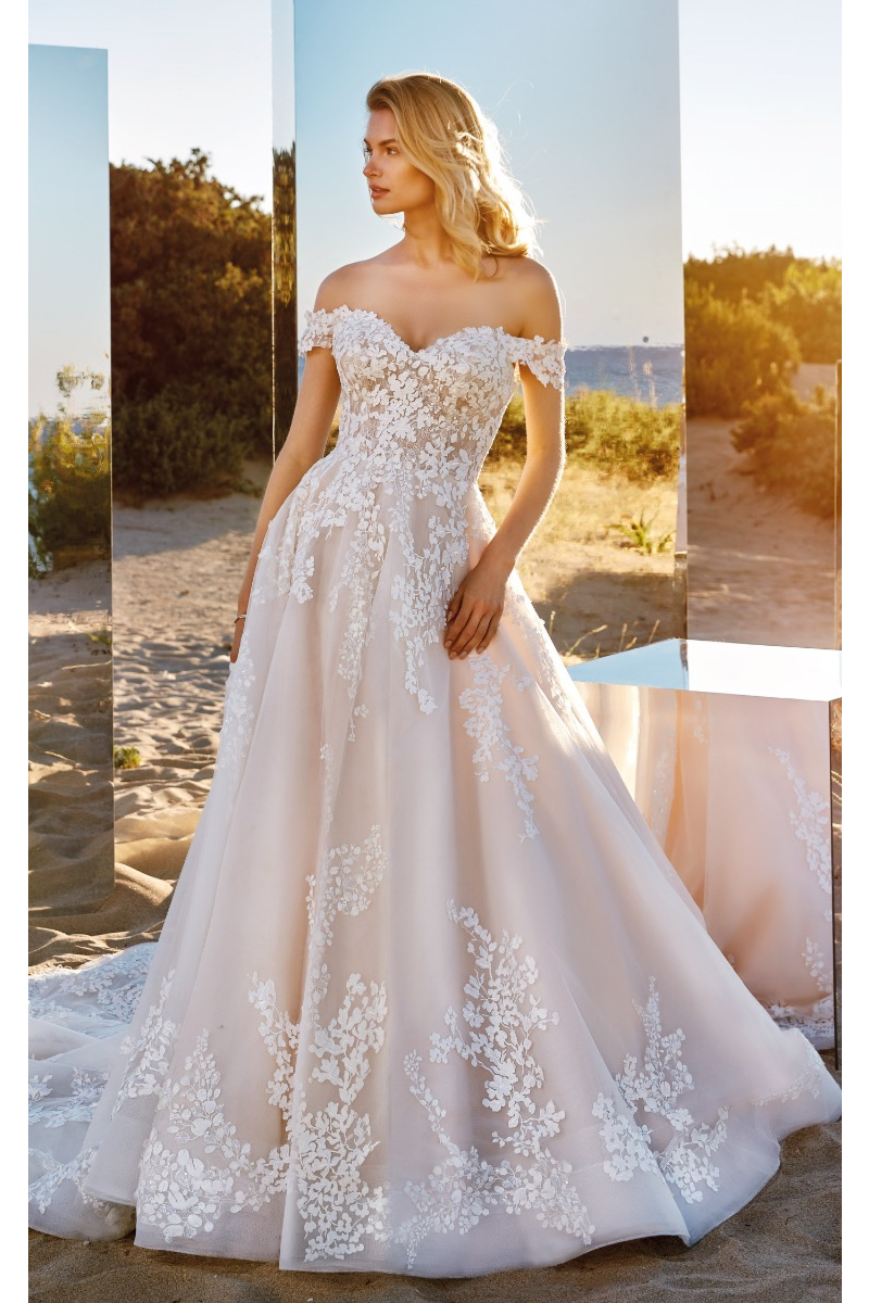 Abito da sposa Electra Eddy K, elegante e romantico, con dettagli in pizzo floreale, sfondo naturale.