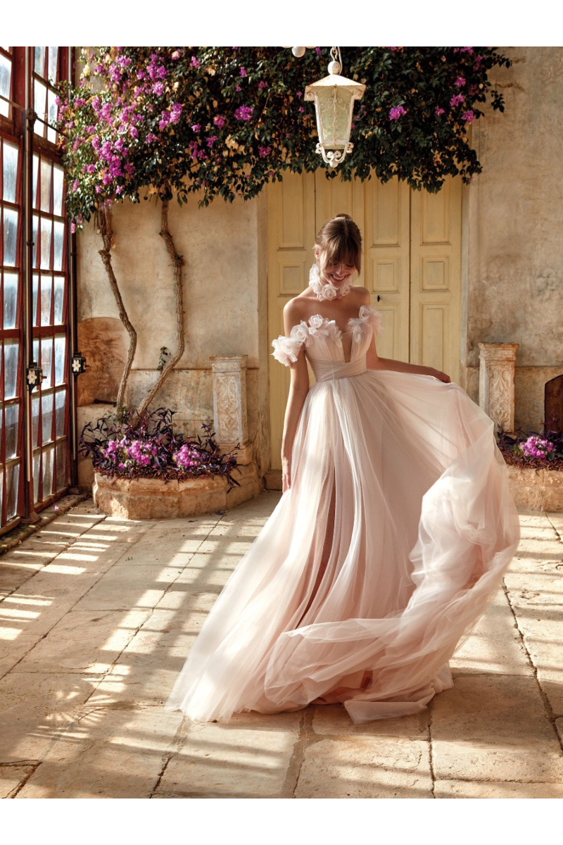 Abito da sposa ELESTREN di Nicole Colet in giardino fiorito, design romantico e dettagli floreali.