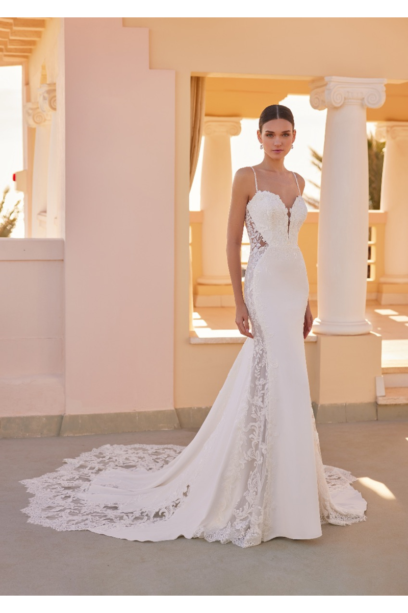 Abito da sposa ELLIOT di St. Patrick con pizzo e strascico, ambientato in una location elegante con colonne.