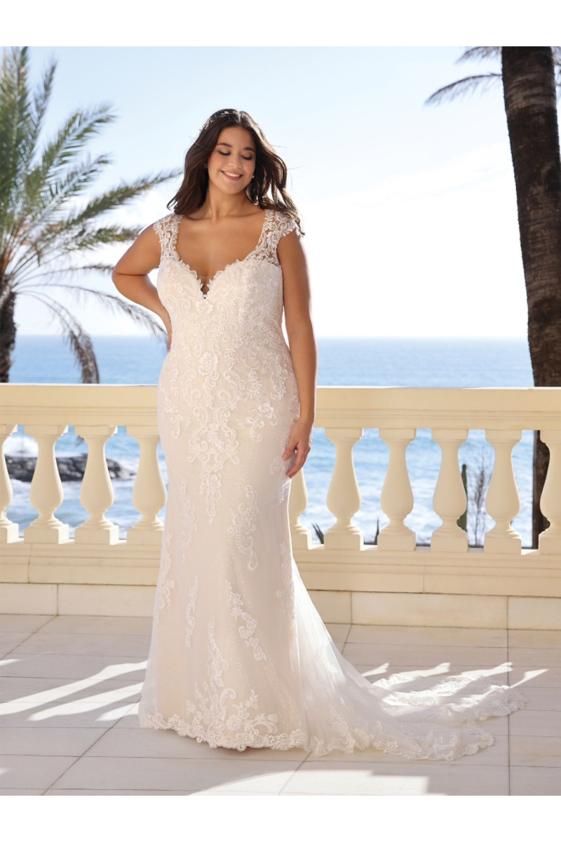 Abito da sposa EVINA Ladybird in pizzo bianco, sfondo mare e palme.