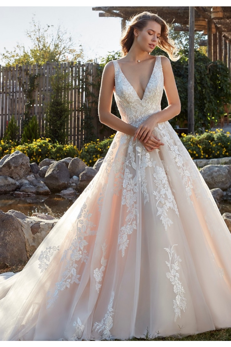 Abito da sposa Geneva Eddy K con ricami floreali e scollo a V, ambientato in un giardino roccioso.