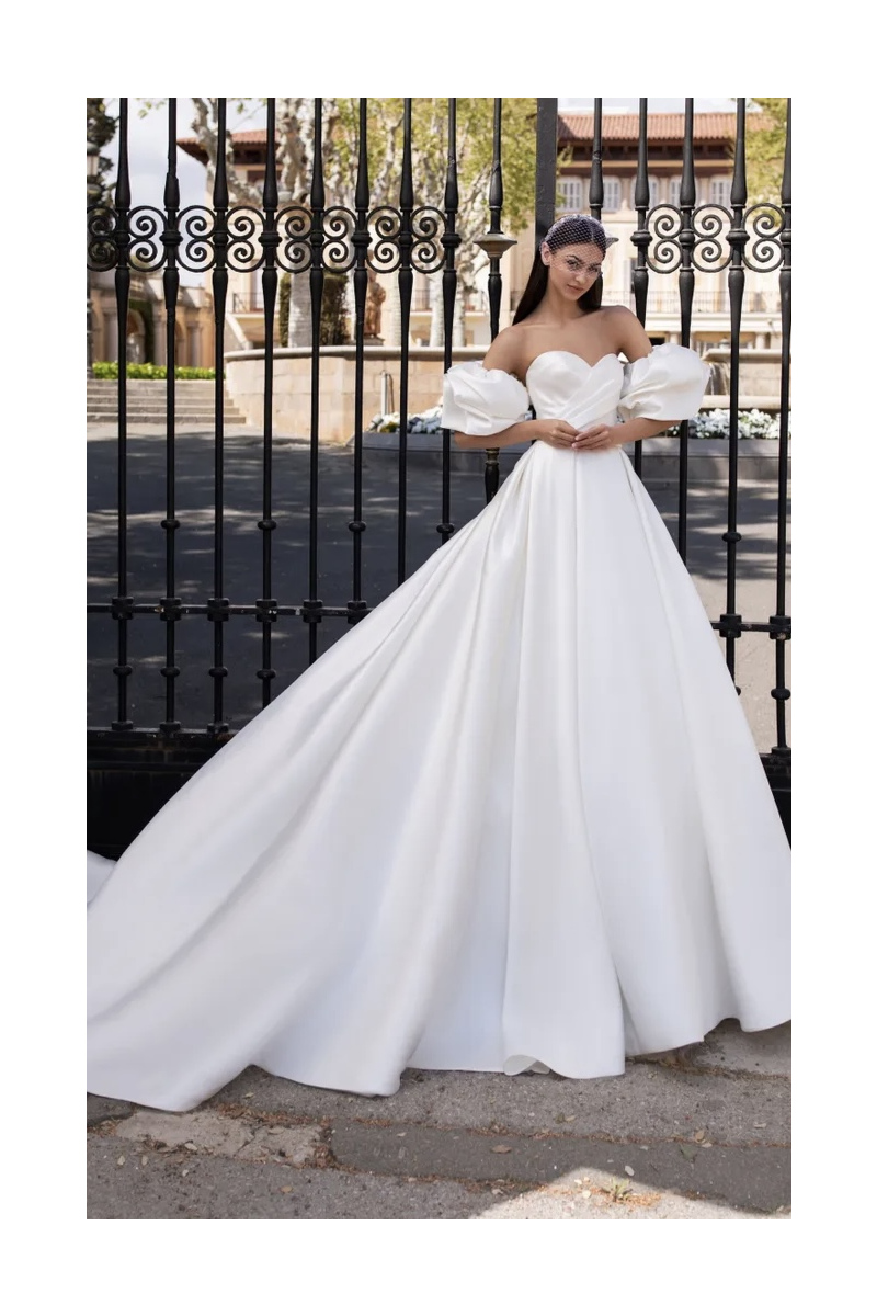 Abito da sposa Pronovias IXION con maniche a sbuffo, sfondo cancello in ferro battuto.