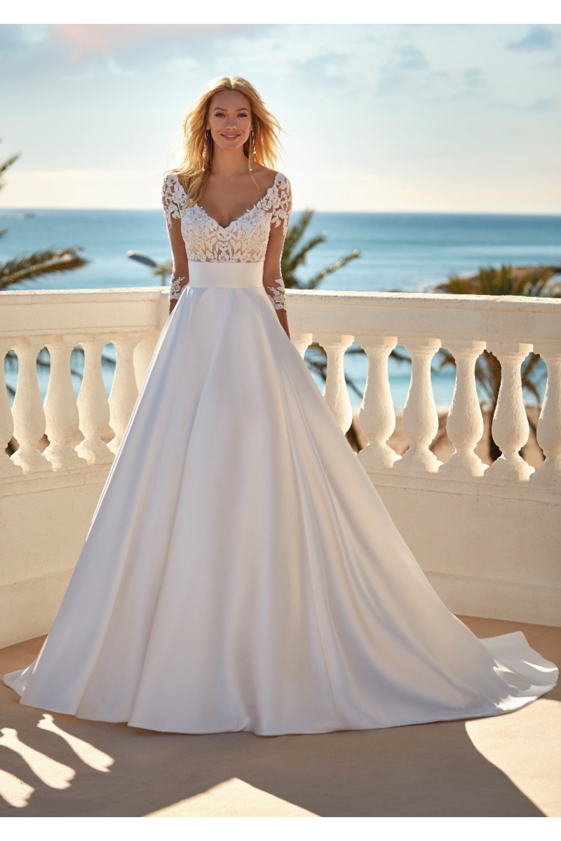 Abito da sposa FABIA in pizzo e seta, sfondo mare, elegante e romantico.