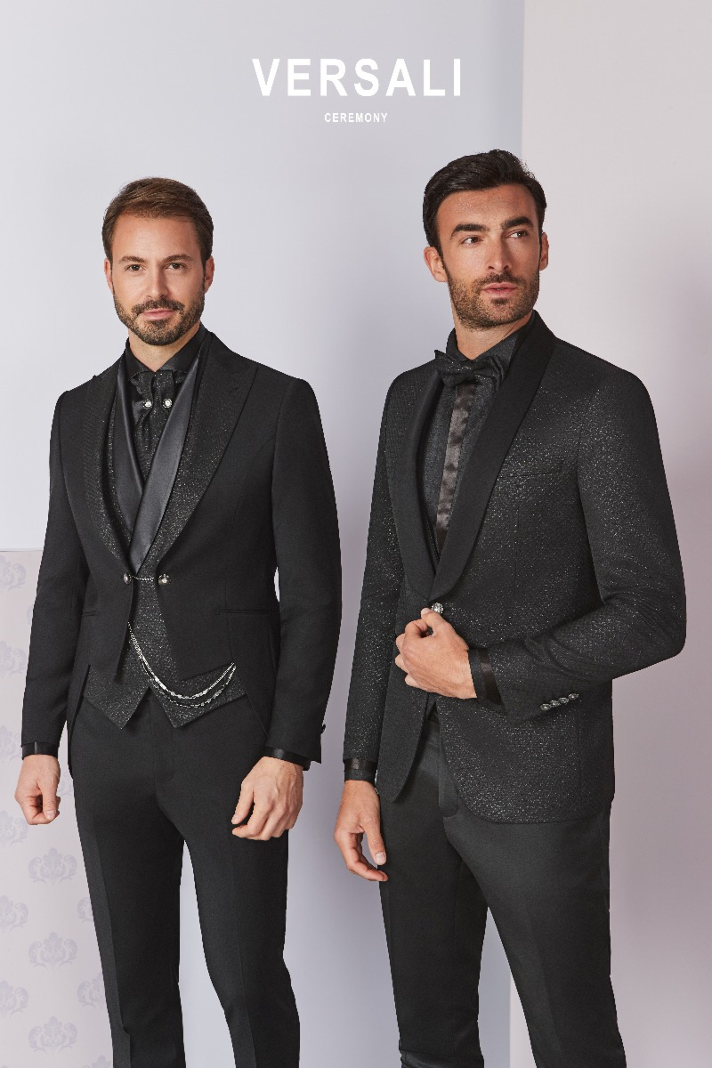 Abiti eleganti da cerimonia neri, modello FIT 03 04, indossati da due uomini su sfondo chiaro.