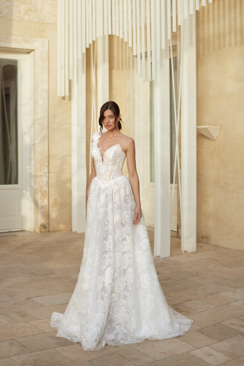 Abito da sposa FLUORITE di Mark Loren, elegante e romantico, con dettagli floreali, indossato in un ambiente esterno.