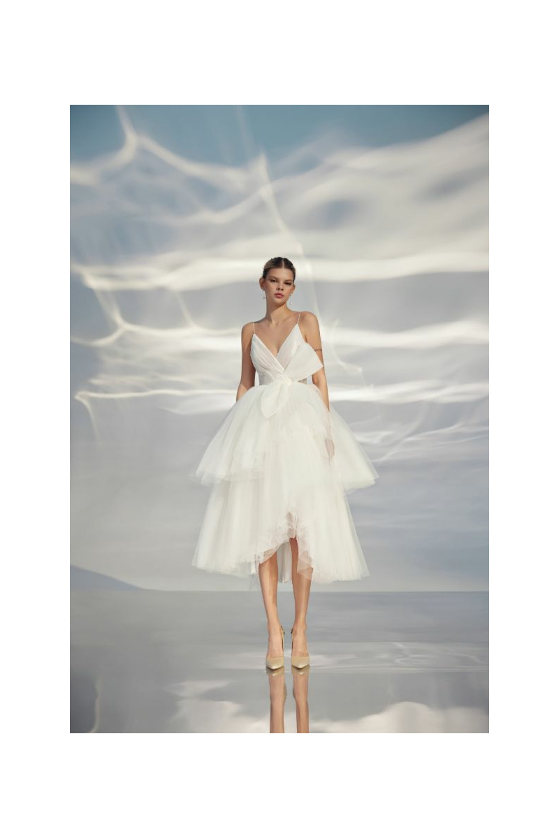 Abito da sposa L314 ARIAMO LIGHT in tulle bianco con dettagli a fiocco, sfondo etereo.