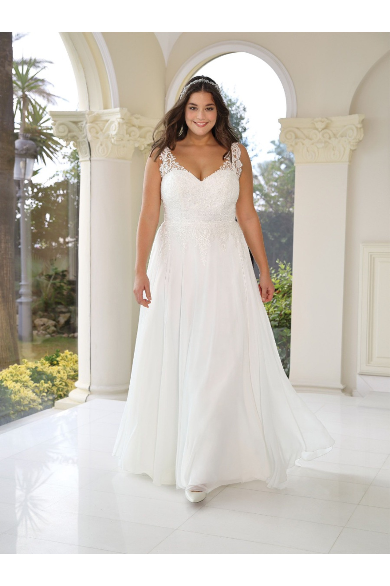 Abito da sposa Layla Ladybird in pizzo bianco, modello curvy, ambientato in un elegante portico.