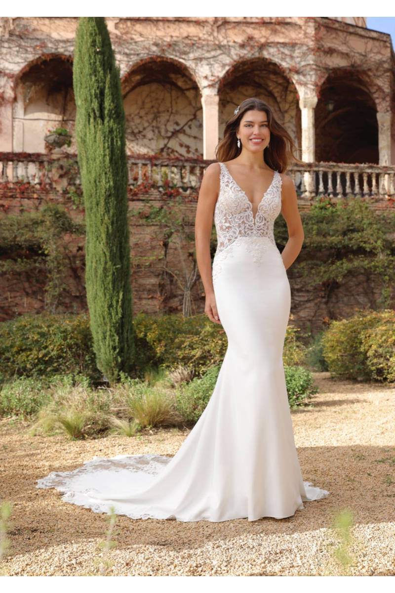Abito da sposa Liber Ladybird in pizzo e seta, donna sorridente in giardino storico.