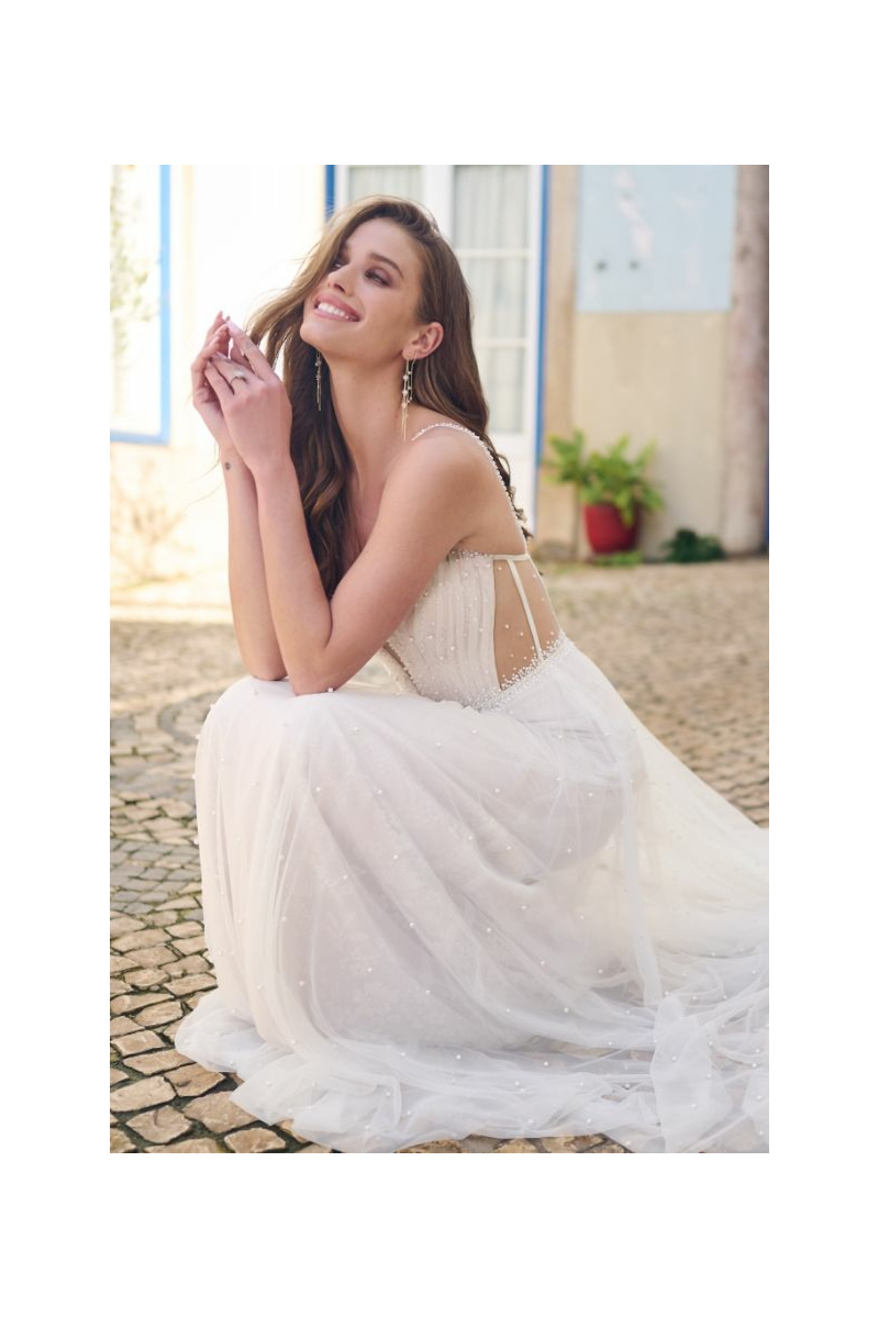 Abito da sposa BETSY di Maggie Sottero, con dettagli in perline e schiena scoperta, indossato all'aperto.