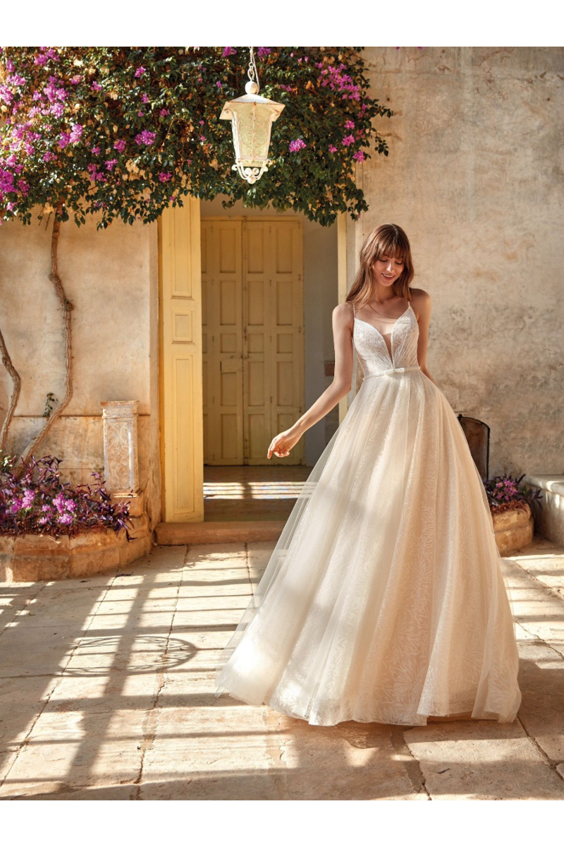 Abito da sposa Marganita in giardino con fiori e lanterna, design elegante e romantico.