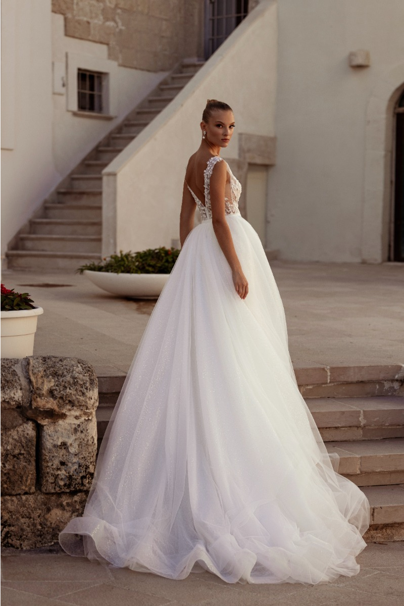 Abito da sposa MIMOSA di MADIONI, elegante design in pizzo e tulle, schiena scoperta, ambientazione esterna.