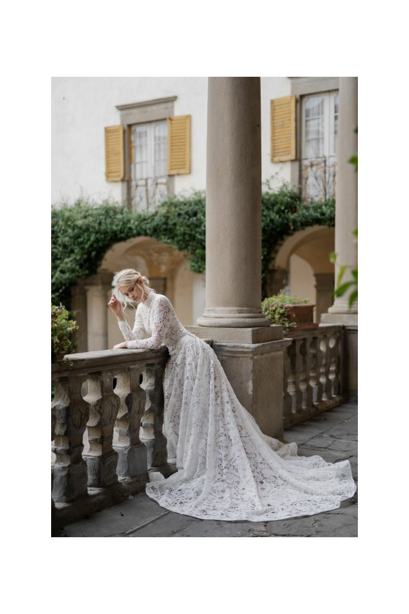 Abito da sposa in pizzo bianco Giulia, Linea Sposae Atelier, su balcone storico con colonne.