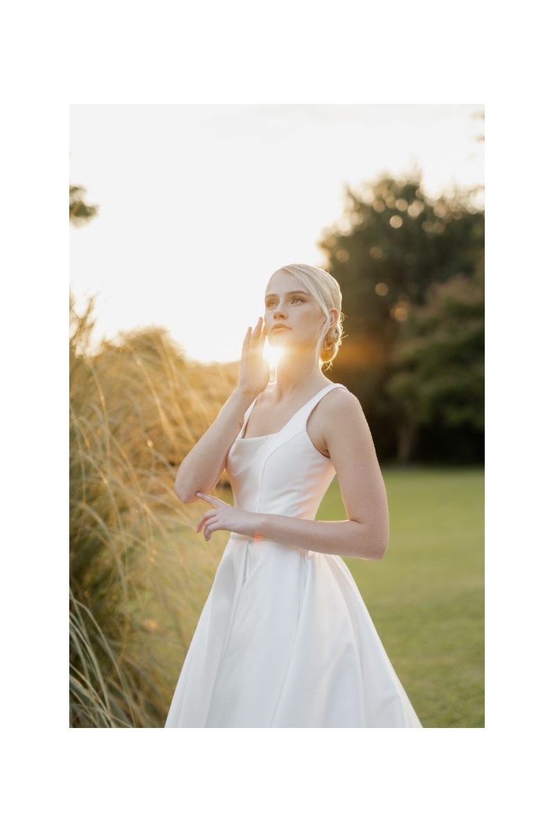 Abito da sposa BERLINO di Sposae Atelier, donna in giardino al tramonto, eleganza e stile.