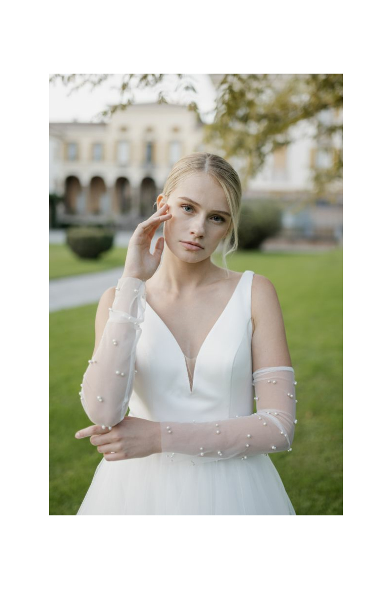 Abito da sposa MIRA di Sposae Atelier con dettagli in perle, indossato in giardino.