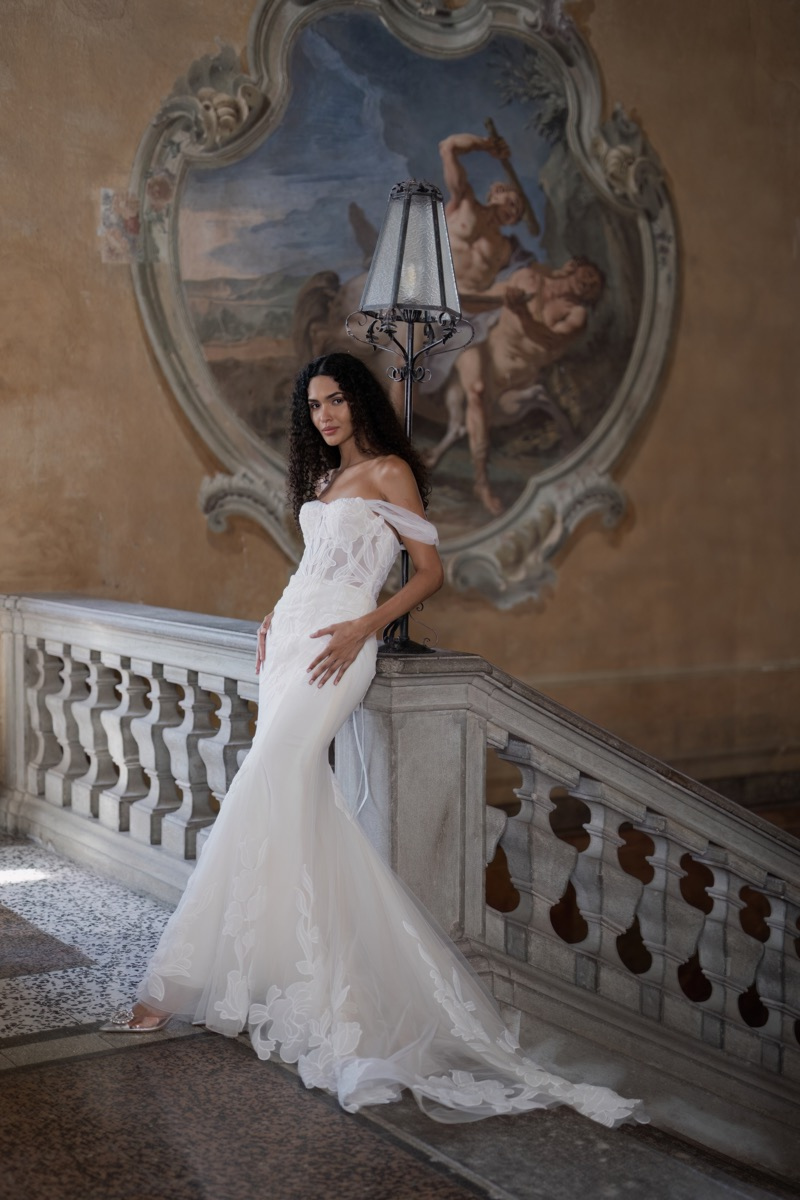 Abito da sposa Halley di Sposae Atelier su modella, scalinata elegante, affresco sullo sfondo.